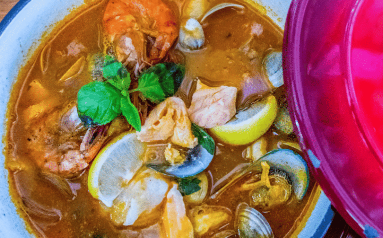 Seafood stew in a rich tomato broth garnished with fresh lemon.