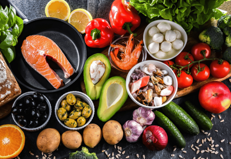 Healthy spread of salmon, avocado, veggies, and olive oil.