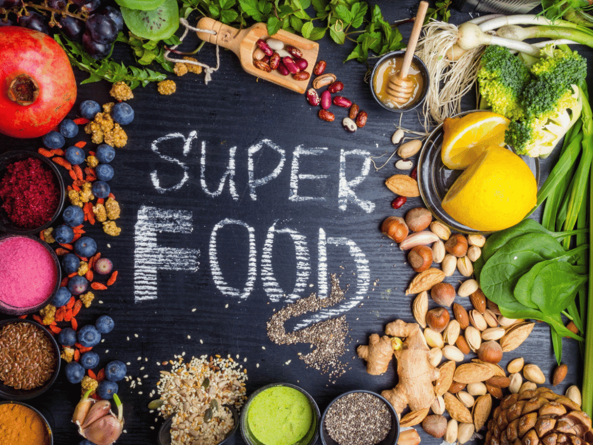 Chalkboard with "Super Food" surrounded by healthy proteins, veggies, and nuts.